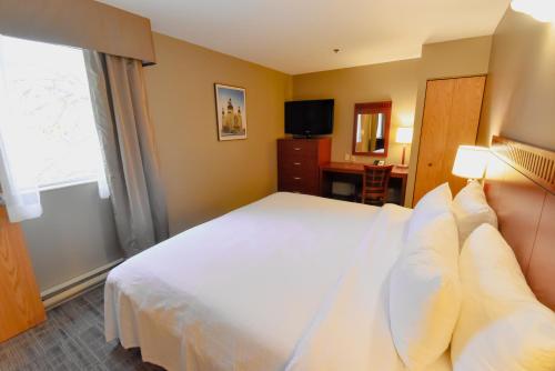 a hotel room with a bed and a window at Canad Inns Destination Centre Fort Garry in Winnipeg