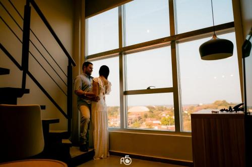 a man and a woman standing in front of a window at Hotel Le Pelican in Asunción