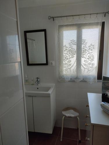 baño blanco con lavabo y ventana en Casa Benlindha, en Degolados