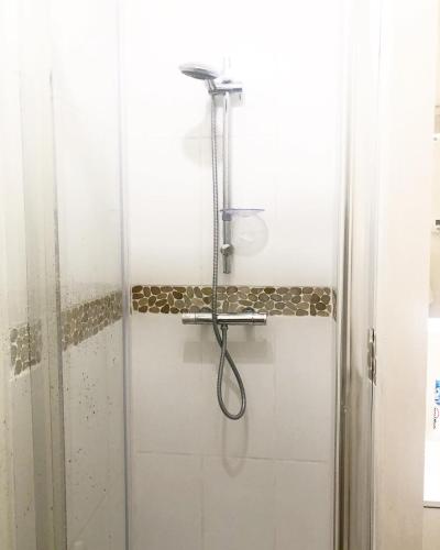 une douche avec un tuyau dans une salle de bain dans l'établissement L escapade, à Capbreton