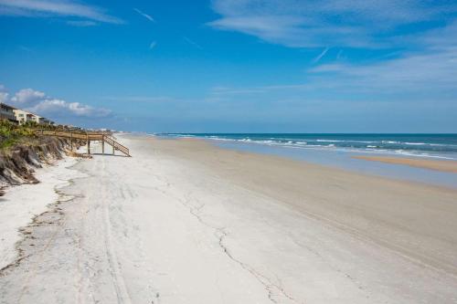a sandy beach with a pier and the ocean at Sunrise Terrace in St. Augustine