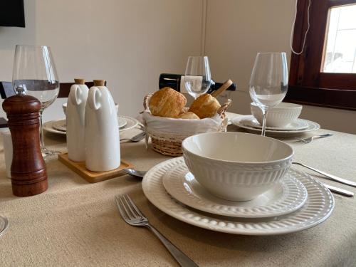 una mesa con un tazón, platos y copas de vino en Apartamento Completo en el centro de Durazno, en Durazno