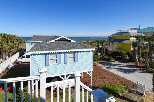 a blue house with a white fence at Beachcomber Penthouse in St. Augustine