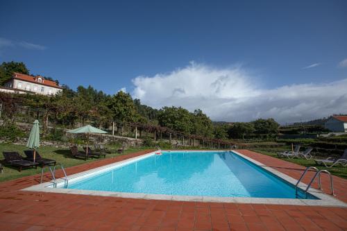 ein großer Pool in der Mitte eines Gartens in der Unterkunft Quinta São Francisco Rural Resort - Regina Hotel Group in Viana do Castelo