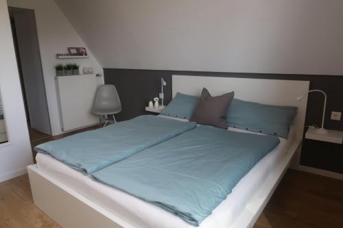 a bedroom with a large bed with blue sheets at Die kleine Auszeit in Gescher