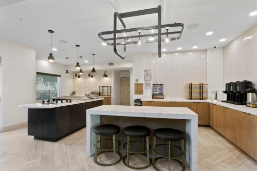 a large kitchen with two bar stools at a counter at Staybridge Suites - Atlanta NE - Duluth by IHG in Duluth