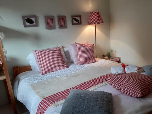 a bedroom with two beds with red and white pillows at HIŠA ANTONIJA-APARTMA IRINKA in Fokovci