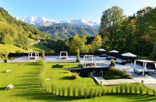 vistas a un parque con montañas en el fondo en Das Graseck - mountain hideaway & health care, en Garmisch-Partenkirchen