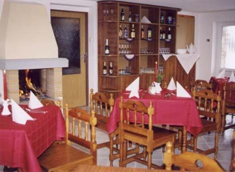 comedor con mesa, sillas y chimenea en Vila Altwaldorf B&B Vysoke Tatry, en Stará Lesná