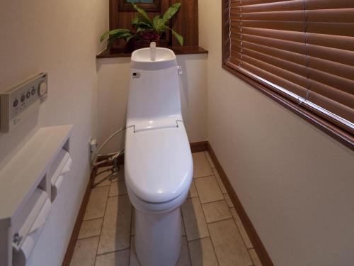 a white toilet in a bathroom with a window at Hotel Grand Fine Kyoto Okazaki Heian Jingu Shrine in Kyoto