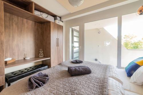 a bedroom with a bed with two pillows on it at LAKE MOMENTS - Emerald Penthouse in Balatonszemes