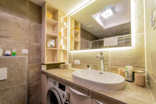 a bathroom with a sink and a washing machine at LAKE MOMENTS - Emerald Penthouse in Balatonszemes