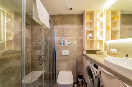a bathroom with a shower and a toilet and a sink at LAKE MOMENTS - Emerald Penthouse in Balatonszemes
