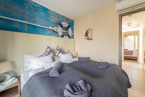 a bedroom with a large bed with towels on it at LAKE MOMENTS - Emerald Penthouse in Balatonszemes