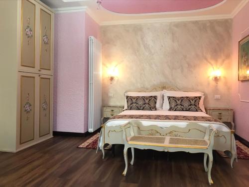 a bedroom with a bed and a pink wall at VECCHIA FAVOLA HOUSE in Quarto dʼAltino
