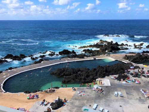 a swimming pool on the beach next to the ocean at Apartment Palma Madeira wandern und tauchen in Caniço