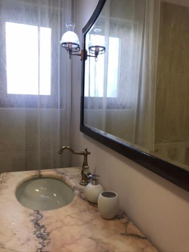 a bathroom with a sink and a mirror at VECCHIA FAVOLA HOUSE in Quarto dʼAltino