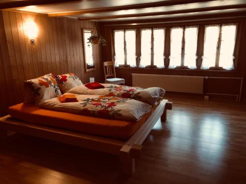ein Schlafzimmer mit einem Bett in einem Zimmer mit Fenstern in der Unterkunft Gemütliches Zuhause mit Ausblick in Wilderswil