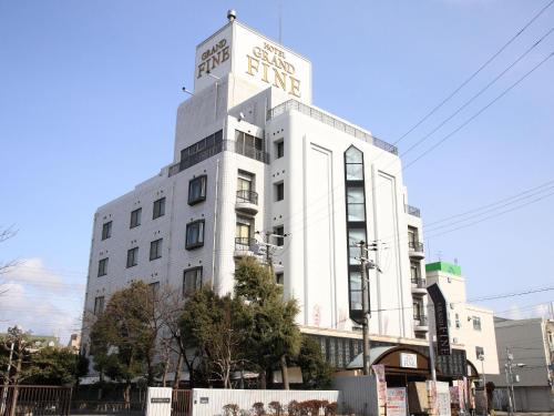 a white building with a sign on the side of it at Hotel Grand Fine Toyonaka Minami in Toyonaka