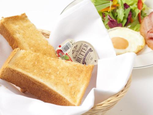 a basket of bread and a salad and a sandwich at Hotel Grand Fine Toyonaka Minami in Toyonaka