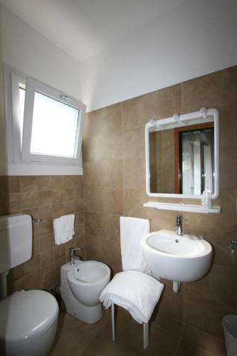 a bathroom with a sink and a toilet and a mirror at Hotel Garden in Lignano Sabbiadoro