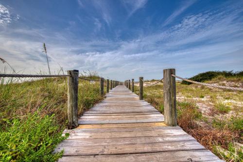 a wooden boardwalk leading to a beach with a blue sky at Gulf Shores Plantation #1262 in Gulf Shores