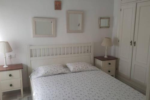 - une chambre avec un lit blanc et 2 tables de chevet dans l'établissement Apartamento Las Infantas. Centro de Sanlucar., à Sanlúcar de Barrameda