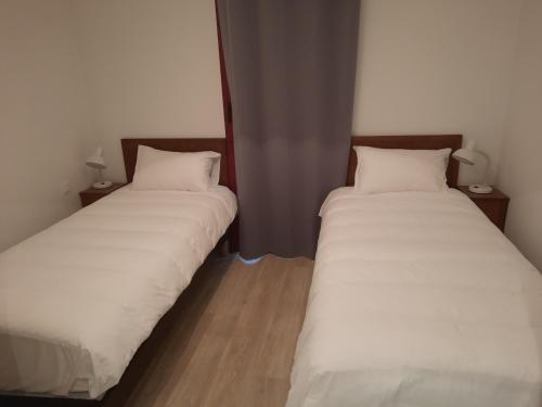 dos camas sentadas una al lado de la otra en una habitación en Gîte chêne - Domaine de Vermoise, en Sainte-Maure