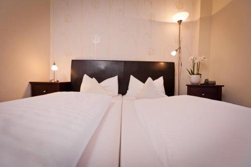 a bedroom with a large white bed with white pillows at Hotel Spies in Gladenbach