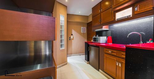 a kitchen with red counter tops and wooden cabinets at NOHO Boutique Koukaki , premium living in Athens