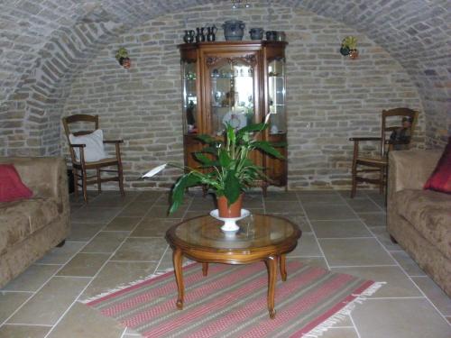 a living room with a table with a plant on it at Logis Saint Martin in Magny-lès-Villers