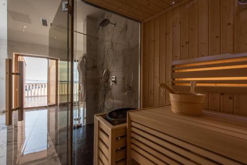 a sauna with a shower and a glass door at Suites Kod Guste in Sukošan