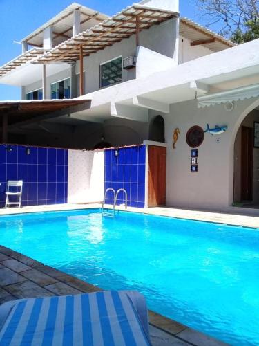 a swimming pool in front of a house at Pousada Recanto do Mar in Saquarema