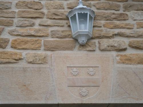 a street light on the side of a stone wall at Logis Saint Martin in Magny-lès-Villers