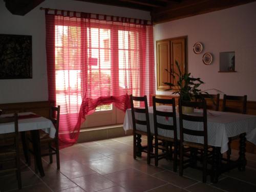 a dining room with a table and chairs and a window at Logis Saint Martin in Magny-lès-Villers