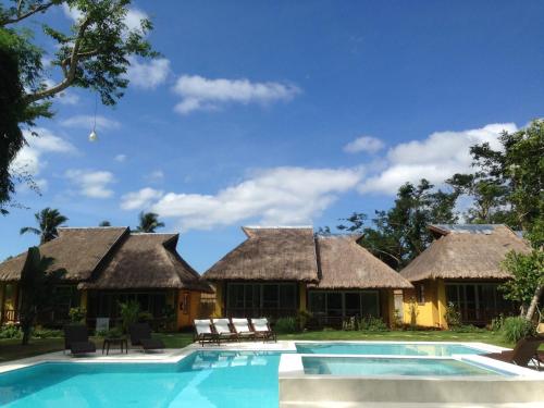 a resort with a swimming pool and two huts at La Natura Resort in Coron
