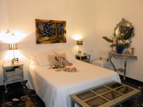 Art&Kitchen في سافونا: غرفة نوم بها سرير أبيض وعليه زهور