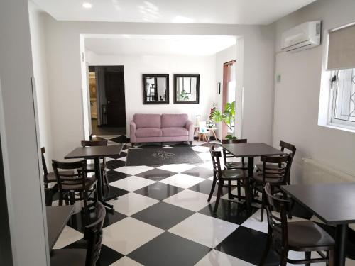a living room with tables and a pink couch at Hotel Elisa Cole in Santiago