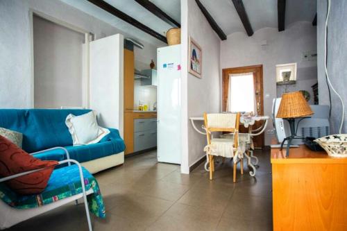 a living room with a blue couch and a table at Apartamento Mestre Caballero in L'Ametlla de Mar