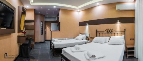 アテネにあるNOHO Boutique Koukaki , premium livingのベッド2台、薄型テレビが備わるホテルルームです。
