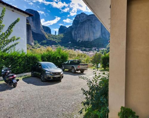 a car and a truck parked in a parking lot at Spartacus House in Kalabaka