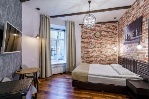 a bedroom with a bed and a brick wall at Adam`s House in Saint Petersburg