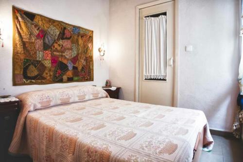 ラメトリャ・デ・マールにあるApartamento Mestre Caballeroのベッドルーム1室(ベッド1台付)が備わります。壁には絵画が飾られています。