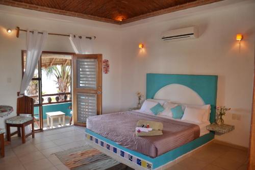 1 dormitorio con 1 cama grande y balcón en Nacional Beach Club & Bungalows en Mahahual