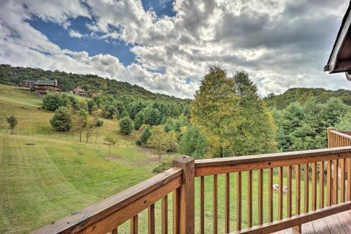 a wooden balcony with a view of a field and trees at half Mi to River Spacious Blue Ridge Gem with Views! in Piney Creek