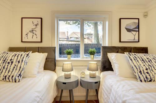 two beds in a room with a window at Leamington Spa Warwick Place Apartments in Leamington Spa