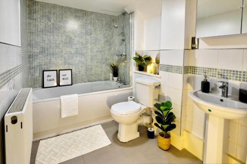 a bathroom with a toilet and a sink and a tub at Leamington Spa Warwick Place Apartments in Leamington Spa