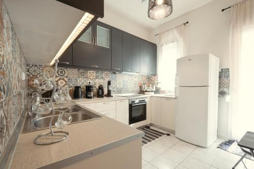 a kitchen with a sink and a white refrigerator at Bay View in Limenas