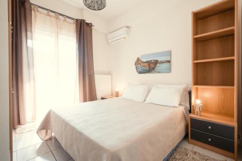 a bedroom with a white bed and a window at Bay View in Limenas