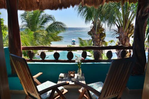 a view of the beach from a room with two chairs at Nacional Beach Club & Bungalows in Mahahual